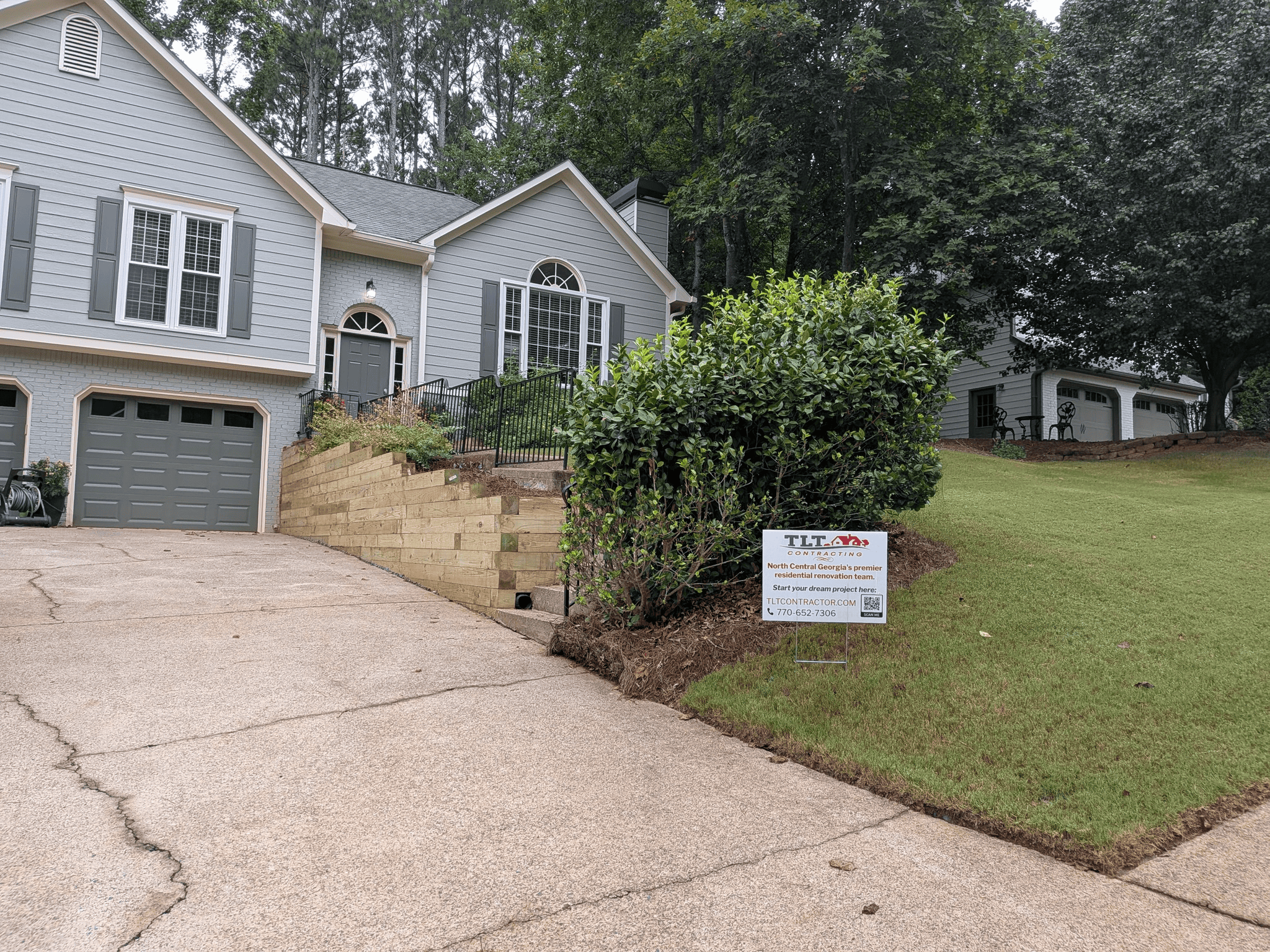 Modern house with landscaped yard and new driveway in a suburban neighborhood.
