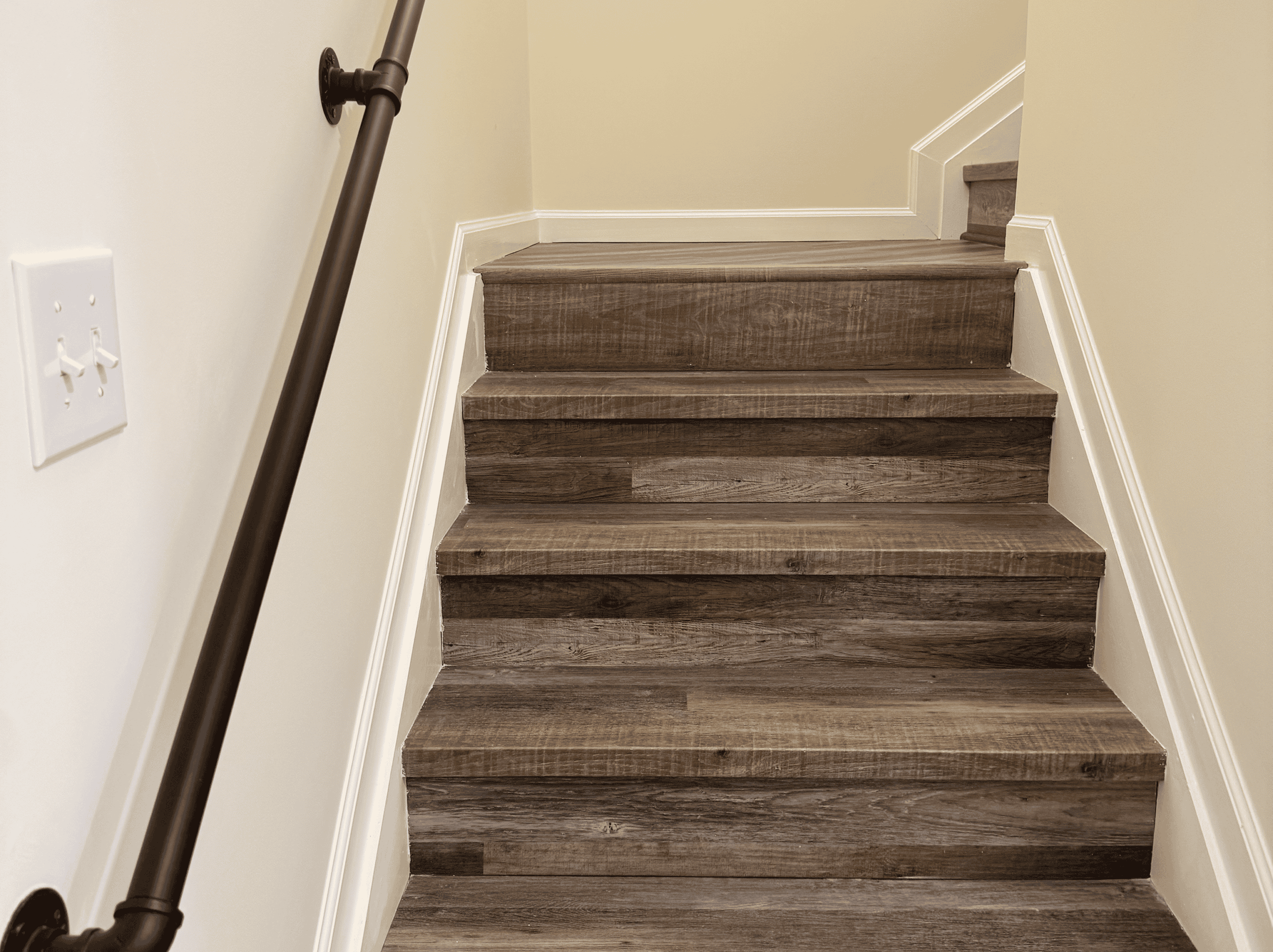 Modern wooden staircase with handrail in a residential interior for safe and stylish access to upper.