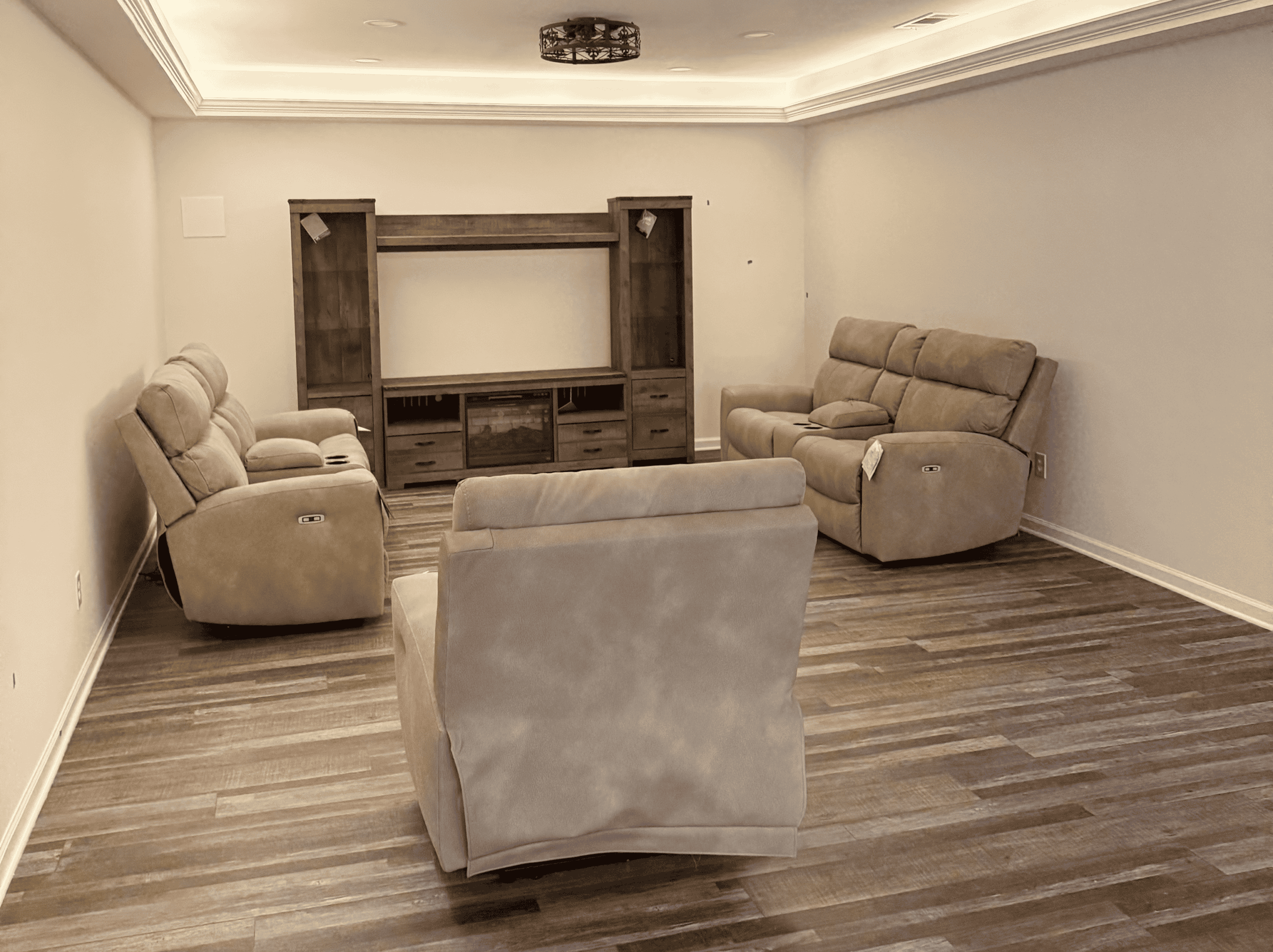 Comfortable living room with beige sofas and wooden entertainment center.