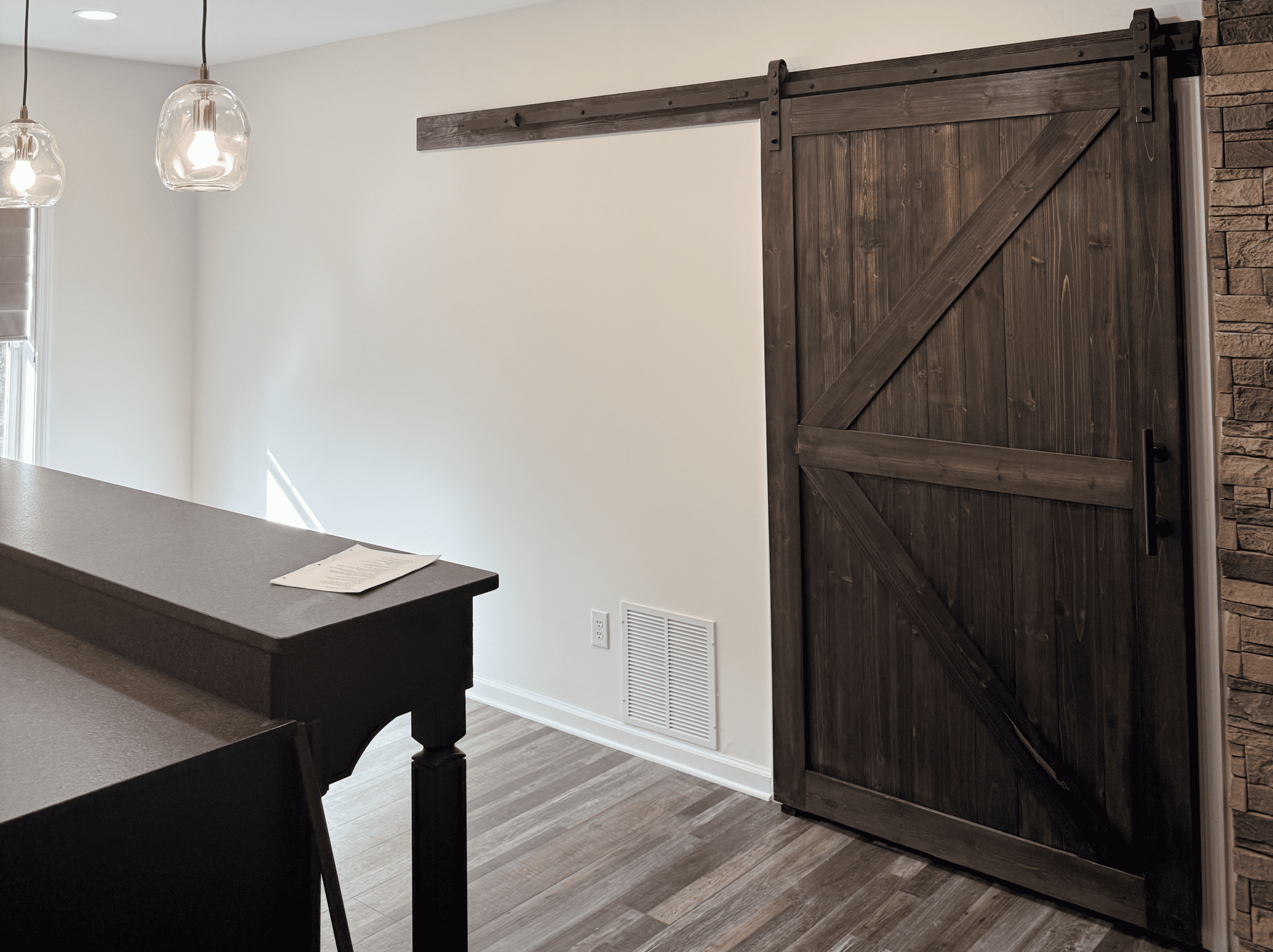 Sliding barn door with dark wood finish in a modern home interior.