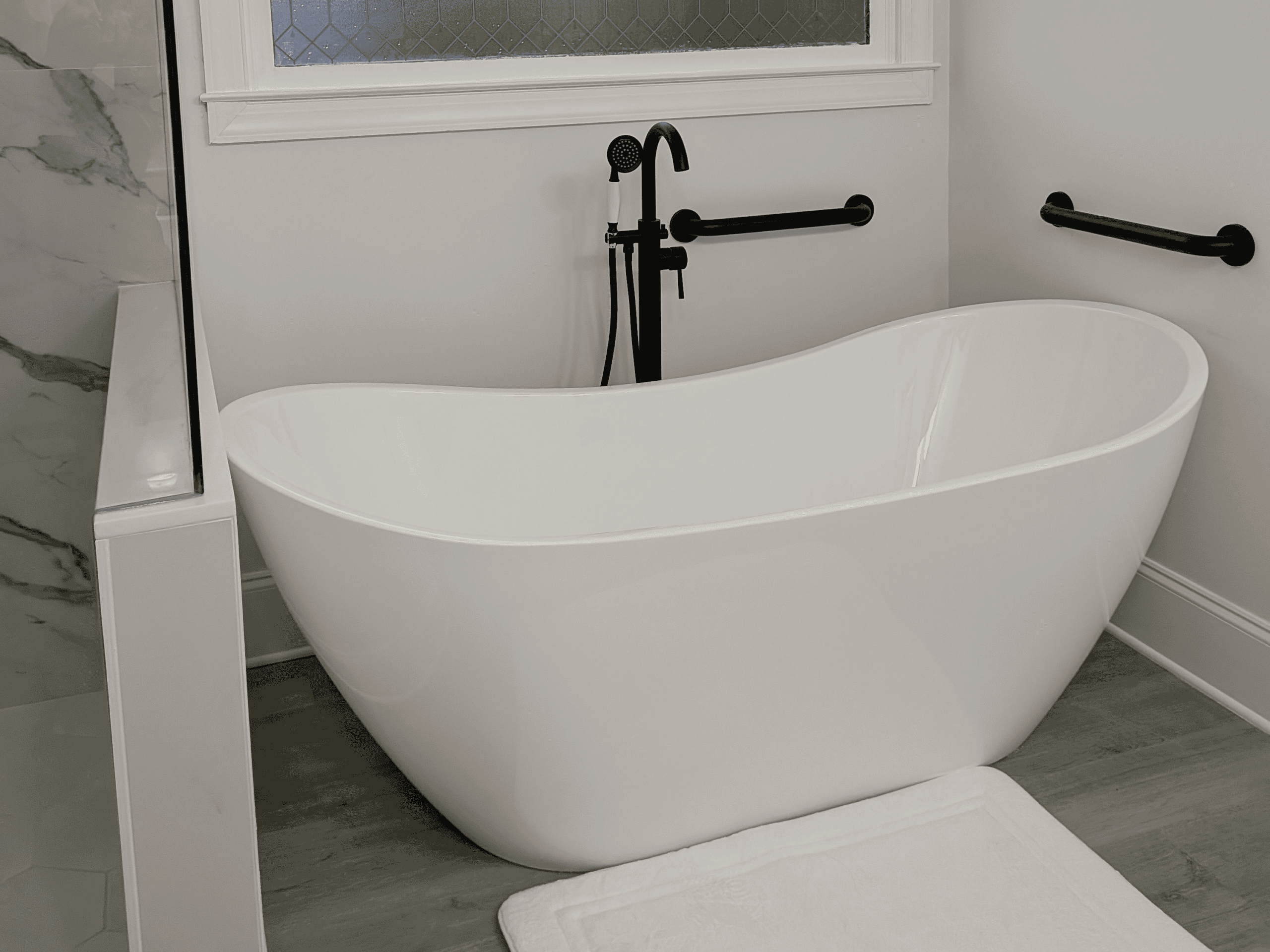 Modern Freestanding Bathtub Freestanding bathtub with sleek black fixtures in a contemporary bathroom setting.