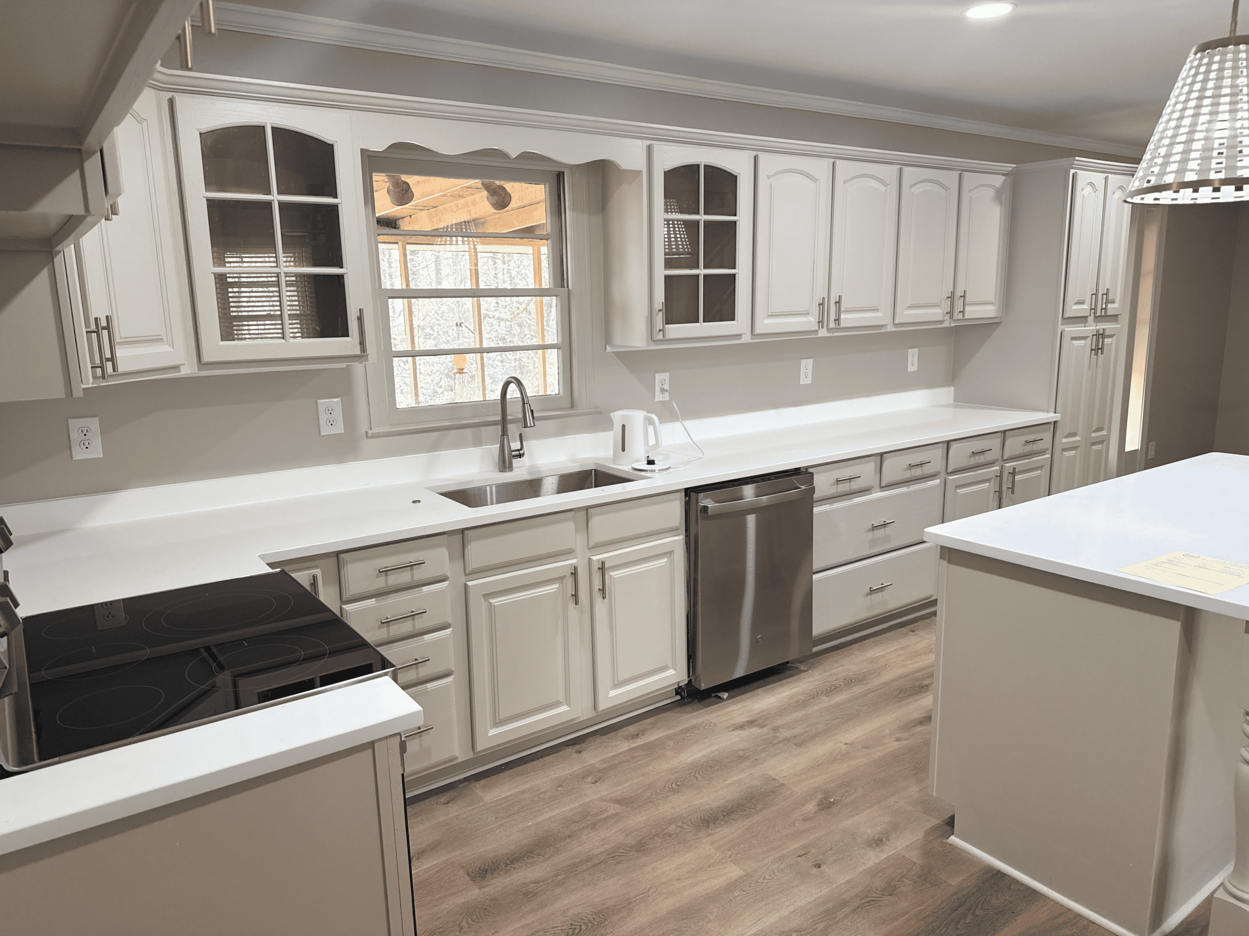Kitchen Renovation Modern white kitchen with cabinetry, stainless steel appliances, and ample counter space.