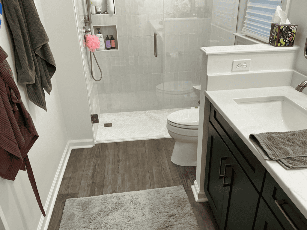 Bathroom with walk-in shower, toilet, and modern vanity with storage.