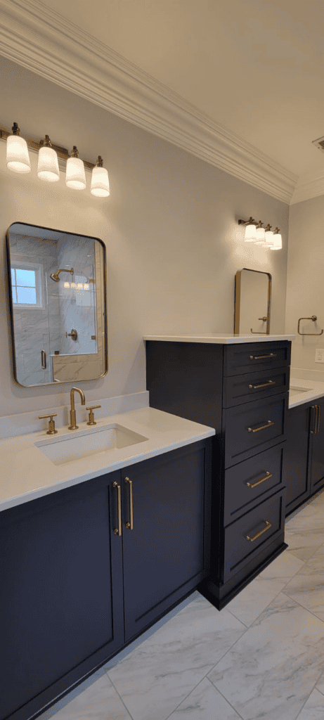 Elegant navy blue bathroom vanity with gold fixtures and dual mirrors.