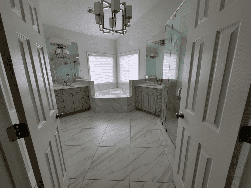 Spacious bathroom featuring dual vanities, a glass-enclosed shower, and elegant marble flooring for.