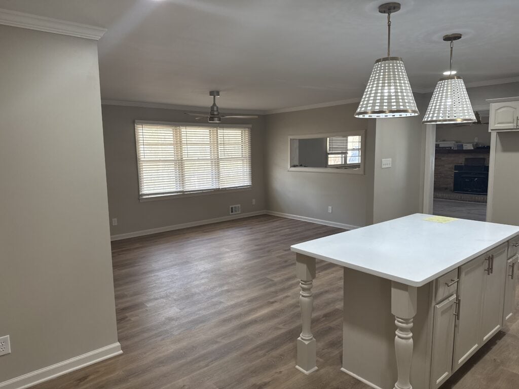 Bright, spacious living room with large windows and hardwood floors.