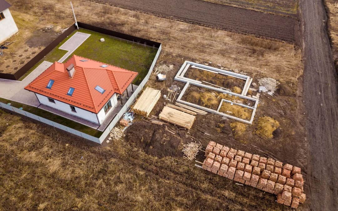 Aerial view of a house construction site with foundation and building materials.