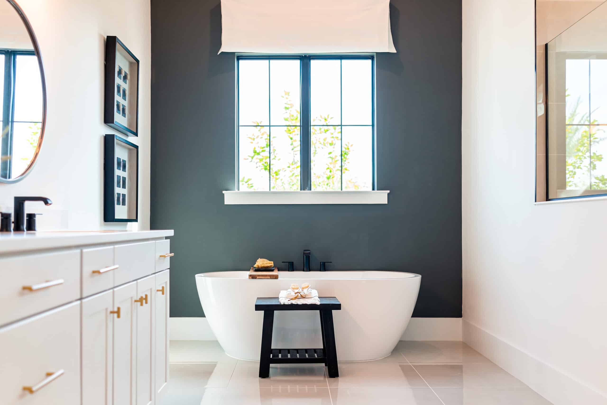 Elegant bathroom with a freestanding bathtub, large window, and minimalist decor.